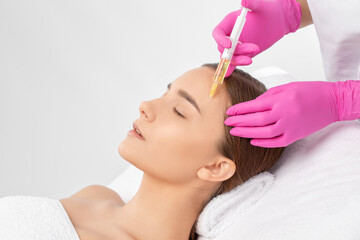 Fototapeta premium Cosmetologist does prp therapy on the face of a beautiful woman in a beauty salon. Cosmetology concept.