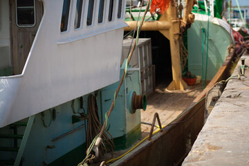 Green and white fishing boat moored at the quay in a harbour © Bjorn B