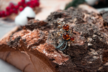 Decoration of amber and bronze in the form of a flower on a wooden background