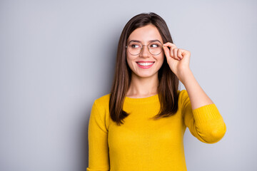 Portrait of attractive cheerful clever girl touching specs looking aside copy space isolated over grey color background