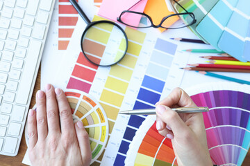 Designer develops color combinations on desktop closeup