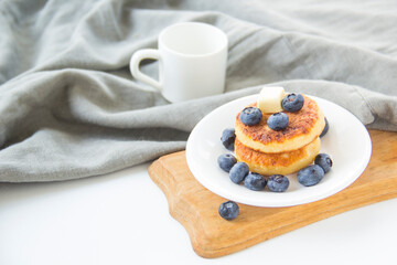 A healthy breakfast of pancakes, berries, butter, and honey