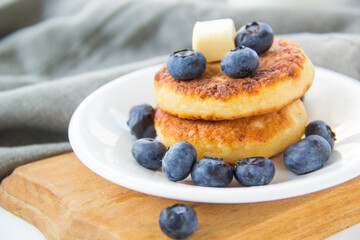 A healthy breakfast of pancakes, berries, butter, and honey