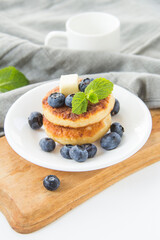 A healthy breakfast of pancakes, berries, butter, and honey