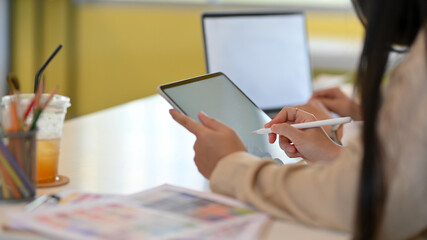 Female office worker hand working mock up digital tablet with stylus pen in office room