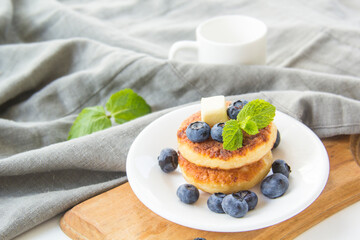 A healthy breakfast of pancakes, berries, butter, and honey
