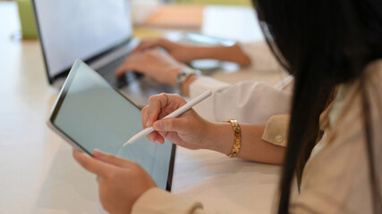 Businesswoman working mock up digital tablet with stylus pen in office room
