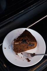 Chocolate pie on a white plate with a spoon on the piano.. Selective focus