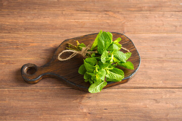 Fresh green mint leaves close-up on a wooden dark background. Mentha piperita plant.