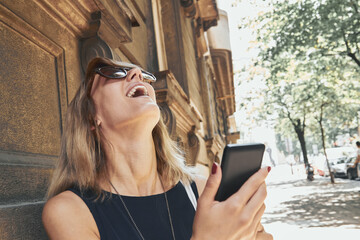 Woman using modern smartphone on the street.