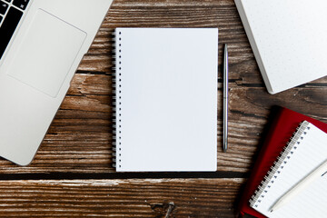 Business office concept. Open notebook with notepads for writing on a wooden table. Widescreen orientation. Remote work on a laptop. Freelance.