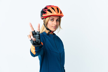 Young blonde Uruguayan cyclist woman isolated on background smiling and showing victory sign
