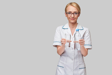 Healthy eating or lifestyle concept - female woman doctor holding and a glass of clear fresh water