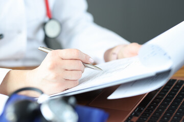 Doctor's hand makes note on medical documents © megaflopp