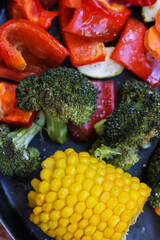 Super tasty, juicy, colorful oven roasted vegetables are lying on the wooden table, super healthy! Close-up, rustic style, top view