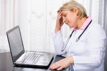 Doctor in a white coat with a stethoscope,thinking. Senior female doctor is tired. The medical worker was overworked from full graphic of online consultations on white medical office background.