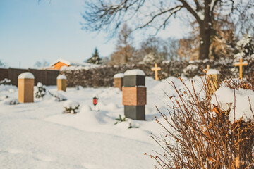 Urnengrab auf Friedhof im Winter bei Schnee Tod und Ewigkeit
