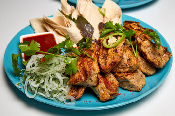 Pork shashlik or Kebab with lavash, pickled onions and red sauce