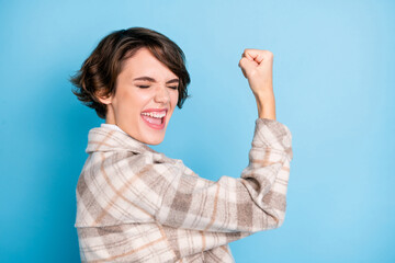 Photo of young excited girl happy positive smile celebrate win victory success fists hand isolated...