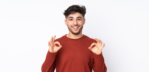 Arabian handsome man over isolated background showing ok sign with two hands