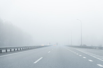 Driver POV of almost empty grey foggy misty rainy highway intercity road with low poor visibility...