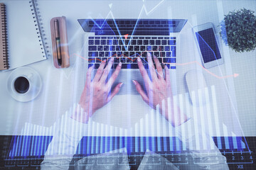 Double exposure of woman hands working on computer and forex chart hologram drawing. Top View. Financial analysis concept.