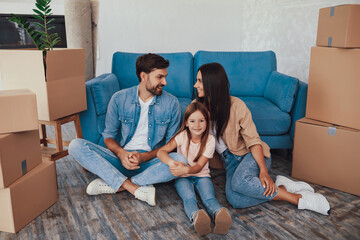 Gladsome child and her happy parents in their new house