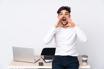 Arabian man in a office isolated on white background shouting and announcing something