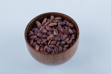 A small wooden bowl full of kidney beans