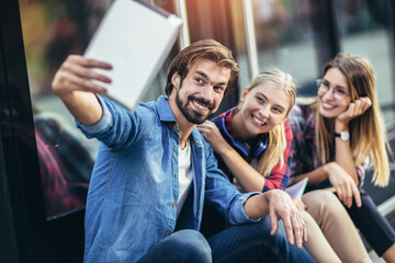 Group of friends taking selfie with tablet pc