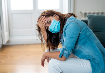 Obraz premium Lonely woman suffering from depression at home during coronavirus lockdown and social distancing
