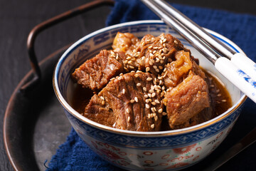 Food concept spot focus Homemade Korean Beef Stew in oriental style porcelain cup on black background with copy space