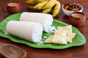 Rice Puttu white Pittu , Kadala Chickpea curry , milk tea , popular South Indian breakfast steamed rice cake Kerala food Tamil Nadu India Sri Lanka. rice flour grated coconut