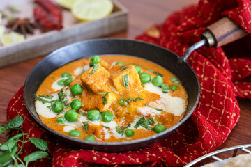 Matar Paneer curry, paneer butter masala recipe made using cottage cheese, green peas, served in a bowl.  Delhi, Rajasthan India. Indian veg curry wooden background. side dish of Roti, Chapati, naan