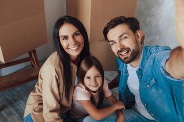 Smiley man taking a selfie with his woman and kid