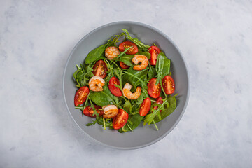 Salad of shrimp prawn and fresh vegetable, leaves of arugula, lettuce.