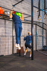 Two young people exercising in the gym in the coronavirus pandemic, a new normal. With protective face mask