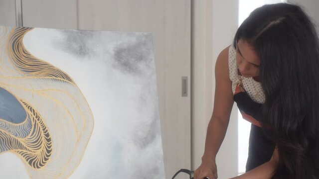 Latina Painter Drying Oil Canvas Artwork Using A Hair Blower. - Medium Shot