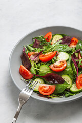 Healthy fresh salad of vegetable cucumber, tomato, spinach, arugula