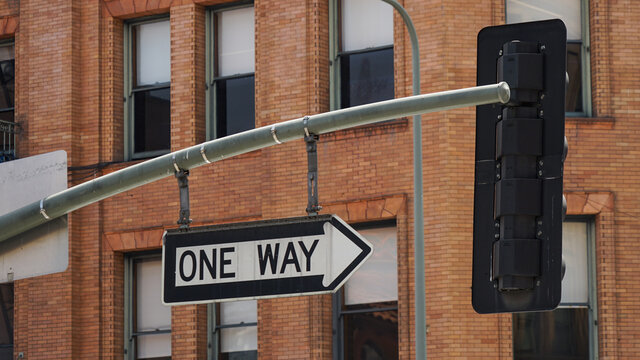 Stra&szlig;enschild One Way Einbahnstra&szlig;e vor einem Backsteingeb&auml;ude