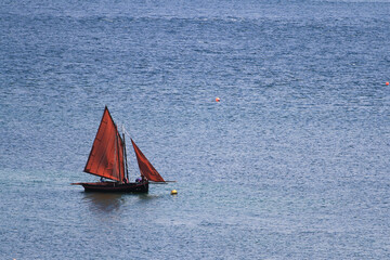 A lone Galway Hooker off the Connemara coast, Ireland, during a summer regatta