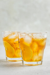 Refreshing summer drink, iced lemon ginger tea in glasses. Space for text.