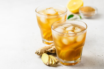 Iced tea with lemon, ginger and brown sugar in glasses. Space for text.