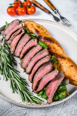 Grilled Homemade rib eye Steak sandwich with sliced roast beef, arugula. White background. Top view