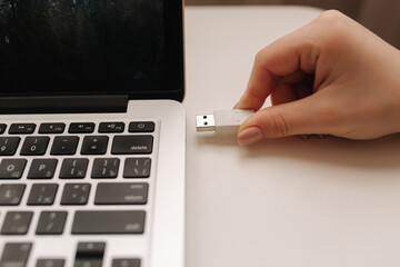 Female hand put USB adapter to copy file by laptop