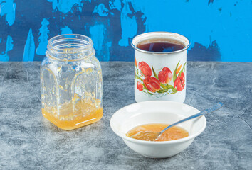 Peaches, jam and cup of tea on marble table