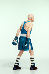 Coach. Senior man wearing sportwear boxing on studio background. Caucasian male model in great shape stays active and sportive. Concept of sport, activity, movement, wellbeing. Copyspace, ad.