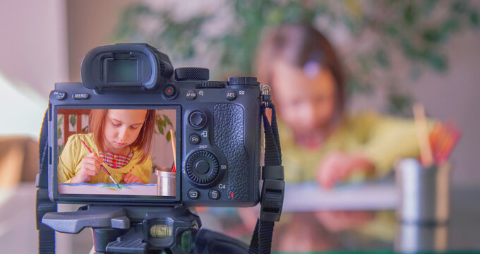 Painting lessons video blogging, vlogs about art and learning. Young attractive beautiful girlpainting colorfull picture with fingers. Process of recording to the camera.