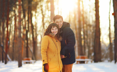 Warm winter portrait of young interracial smiling couple on a walk in the forest