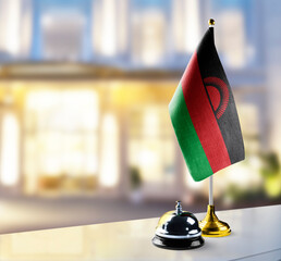 Malawi flag on the reception desk in the lobby of the hotel - obrazy, fototapety, plakaty